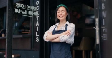 Mutlu Asyalı kadın, kafe ve küçük işletmelerin sahibi. Yönetime güvenerek. Profesyonel bir restoran ya da kafeterya tarafından kolları bağlanmış genç bir kadın ya da garson kızın portresi..