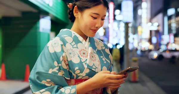 Road, Japanese woman and smartphone with typing, contact or digital app with traditional clothes. Person, outdoor or girl with a cellphone, mobile user or smile with network, chatting or social media.
