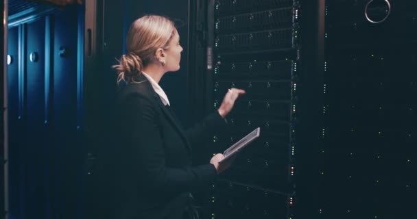 データベースの更新のための貯蔵のエンジニアが付いているタブレット 点検またはネットワーク維持が付いているデータ センターの女性 サーバールームをチェックするデジタルアプリの技術サービス システム管理 技術者 — ストック動画