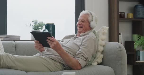 流连忘返 带着平板电脑 在客厅里嬉笑和交流 养恤金领取者在休息室 公寓和老年人在沙发上 笑的应用程序或喜悦 — 图库视频影像