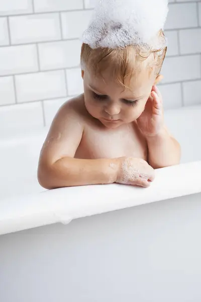 バスタブにいる赤ちゃんは ウェルネス ボディケアで朝のルーチン用の泡と石鹸で掃除します 浴室の水で考える衛生 リラックスした落ち着いた子供と泡で洗うかわいい幼児 — ストック写真