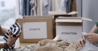 İnsanlar, katlama ve kıyafetler bağış için kutulara, hayır kurumuna ve organizasyonda gönüllü olarak çalışmaya. Kurumsal sosyal sorumluluk ve NGO vakfı cömertliği ile el, paketleme ve sıralama.