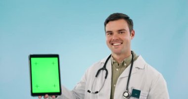 Doktor, klinik sunumu, web sitesi ya da kayıt için başparmaklar yukarı ve tablet yeşil ekran. Dijital model, tele sağlık hizmeti veya mavi arka planda tıbbi alan için sağlık görevlisinin yüzü.