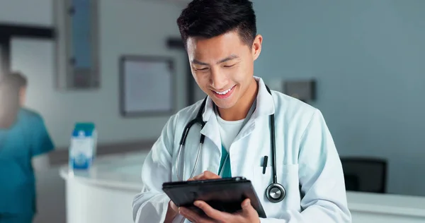 Tablet, healthcare doctor and happy man typing online research, check medicine study and smile for wellness results. Hospital service, happiness and surgeon reading clinic review, feedback or news.