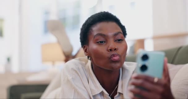 非洲女人 自私自利 在沙发上亲吻 微笑着 用手势 情感或记忆的嘴唇在网上贴着嘴 有影响力的女孩 个人和生活流为了爱情 社交媒体或在家里的沙发上放松一下 — 图库视频影像