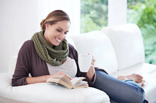 女人和阅读书籍与咖啡在沙发上的故事 小说或爱好在客厅里的家 小说书籍 喝茶以获得文学 知识或舒服地躺在沙发上 — 图库照片