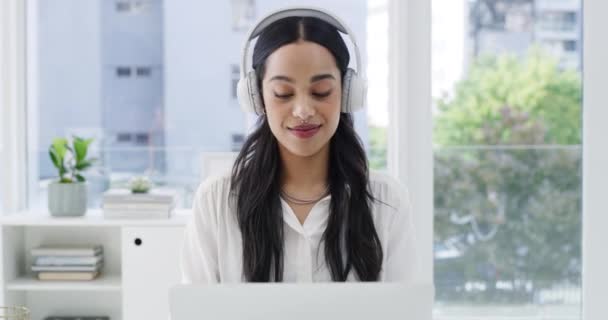 スマイル ビジネス女性がヘッドフォンでオーディオを聞き オフィスで働く音楽のためのラップトップ コンピュータ ダンス オンラインサウンドストリーミングのためだけに職場で幸せな若い従業員とタイピング — ストック動画