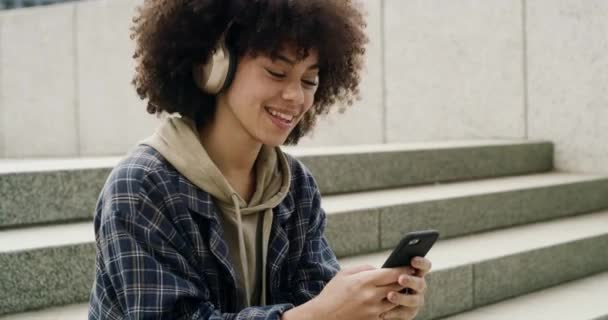 Şehirdeki Kulaklıklar Telefon Afro Kadın Sosyal Medyada Podcast Abonelik Üzerine — Stok video