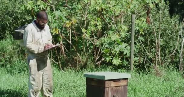 田舎のクリップボードでチェック ノート 書き込みのための農場での個人的な 養蜂家および農業 品質保証 蜂蜜のための蜂による思考のための男 チェックリストまたは文書 — ストック動画