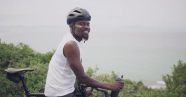 Mutlu siyah adam, bisikletçi ve bisiklet dağ gezisi, egzersiz ya da açık hava kardiyo çalışması için doğada. Afrikalı erkek portresi bisiklet sürerken ya da kaskla güvenlik için bisiklet sürerken gülümsüyor.