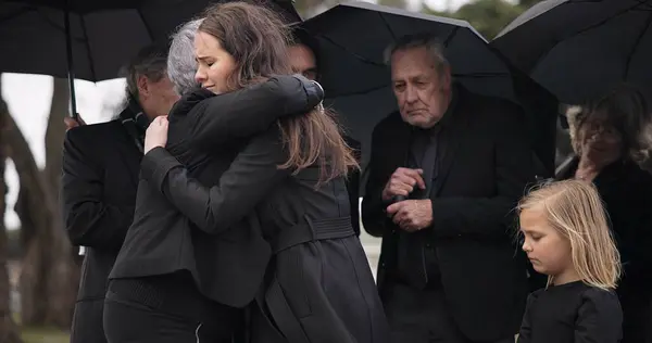 丧葬时 哭着的家人和人们拥抱在悲痛的支持下 哀悼抑郁症和在感情丧葬事件中死亡 在棺材仪式上 妈妈和一群人与寡妇拥抱年长的妈妈 — 图库照片