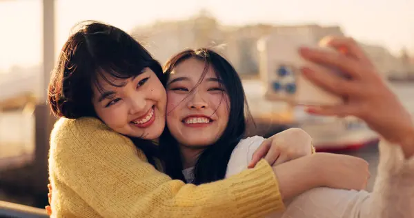 Friends, women and hug with selfie, Japanese influencer team outdoor with memory and social media post. Happiness, friendship date in Kyoto with travel and smile in picture, photography and adventure.