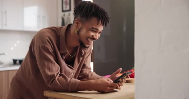 ハッピーマン 自宅でのコミュニケーション ソーシャルメディア ネットワーキングのためのキッチンでのタイピング オンラインチャット テキスト 家での研究のためのスマートフォン上の若い男性の人笑顔 — ストック動画
