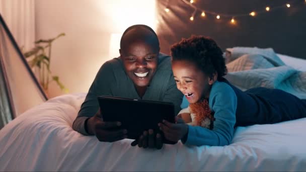 タブレットと父親と息子は または自宅で面白いビデオをストリーミングするベッドで デジタル アプリ ブラックパパパと子供と一緒にオンライン漫画 愛と家で結合 — ストック動画