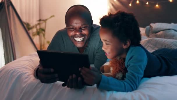 ハッピーな父親 タブレットは オンラインストリーミング エンターテイメント または自宅で映画を見るためにベッドで夜に アフリカのお父さん 子供や息子の笑顔映画のための技術 面白いショーや寝室での漫画 — ストック動画