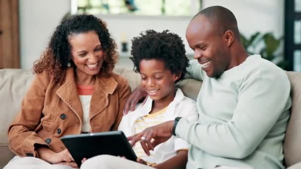 ハッピーブラックファミリー タブレット 面白いジョーク ミーム または自宅でオンラインストリーミングのためにソファーで笑う アフリカの母親 父親と小さな男の子は家で結合するためのリビングルームソファの技術で微笑む — ストック動画