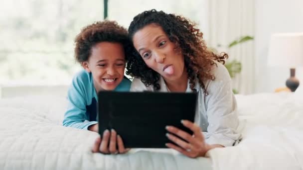 タブレット セルフィー 母親と息子は 自宅でクレイジー 舌のジェスチャーでベッドの上に デジタル プロフィール写真のための寝室で子供と愛 家族とアフリカのママ — ストック動画