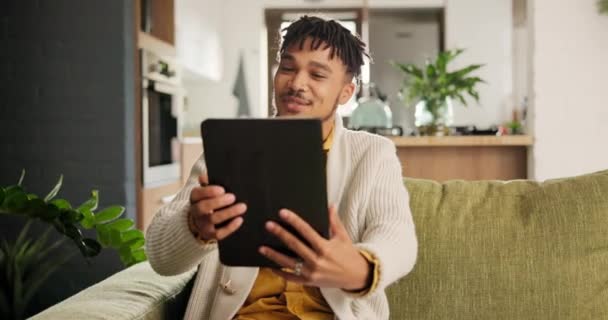 在现代公寓的客厅里 视频电话和沙发上挂着平板电脑的男人在网上聊天 数字技术与年轻男性在家中休息室进行虚拟对话 — 图库视频影像