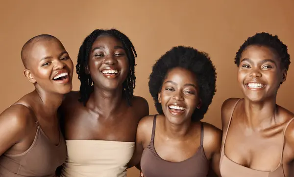 Face, skincare and laughing with black woman friends in studio on a brown background for natural wellness. Portrait, beauty and smile with a group of funny people looking happy at antiaging treatment.