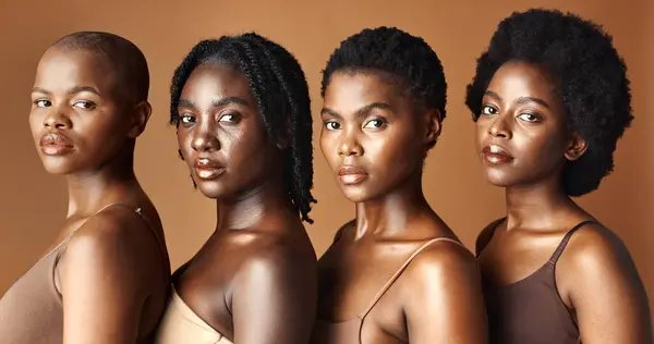 Beauty, face or black women with skincare, glowing skin or afro isolated on brown background. Facial dermatology, models or natural cosmetics for makeup in studio with girl friends or African people.