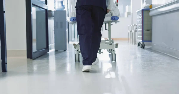 Nurse, feet and walking patient in hospital, bed or steps in hallway or corridor to surgery, operation room or ER healthcare. Doctor, moving and pushing person in clinic to ICU, bedroom or walk.