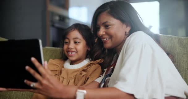 タブレット セルフィー 母親と娘は 愛情を持ってソファーで一緒に家でサポートします ソーシャルメディア ゲーム 写真のためのリビングルームに子供とデジタル プロフィール画像と幸せなママ — ストック動画
