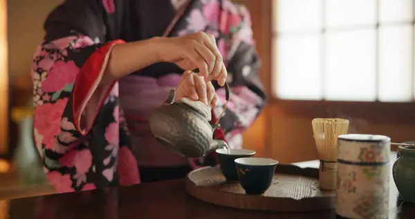 Japanese, hands and matcha for tea ceremony in Chashitsu room with kimono dress and traditional custom. Person, temae and vintage style outfit for culture, fashion and honor with antique crockery.