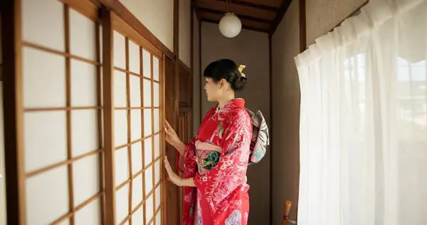 Japan, woman and kimono in corridor for tradition, tea ceremony and hallway of Chashitsu room or door. Entrance, person and vintage dress or fashion for temae, ritual and waiting for hospitality.