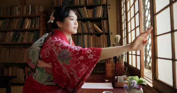 Open window, Japanese and woman with architecture, apartment and morning with culture. Library, calm and zen with sliding door, female person and traditional dress with accommodation in Tokyo.