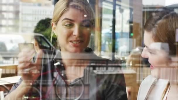 在咖啡馆的窗口 女人和朋友一起聊天或笑着吃早午餐或午餐 赶上或重逢 快乐和在咖啡店聚会 进行社交活动和有趣的故事 — 图库视频影像