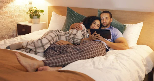 カップル 幸せと夜にタブレット付きのベッドルームでリラックスし 映画や抱擁をストリーミング ソーシャルメディアアプリでベッドの上で笑顔 技術と男性と女性 オンラインビデオを見て 家の中で一緒に結合 — ストック写真