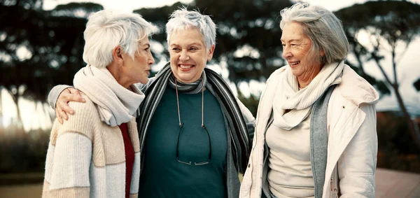 Talking, funny and senior woman friends outdoor in a park together for bonding during retirement. Happy, smile and laughing with a group of elderly people chatting in a garden for humor or fun.