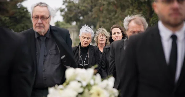 抬着棺材的人 抬着棺材参加葬礼 仪式或哀悼活动的人 带着悲伤 悲伤和鲜花在墓地走着 与家人一起参加追悼会的人 支持和步行 — 图库照片