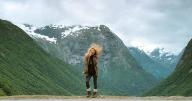 Heyecanlı, doğa ve kadın dağlarda dans ederek özgürlük ve refah için yeşil tepelerde. Gezmek, selamlamak ya da mutlu bayan turist atlamak Stryn, Norveç 'te eğlenceli bir macera kutlaması.