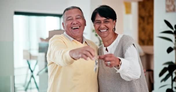 Seniorenpaar Nieuw Huis Sleutels Voor Hypotheeksucces Vastgoedinvestering Pensioen Met Knuffel — Stockvideo