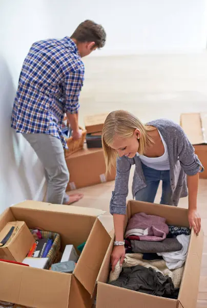 Couple, boxes and packing clothes for moving or homeowner, real estate property or marriage. Man, woman and happy or organize for new apartment or mortgage investment for relocation, buying or rent.