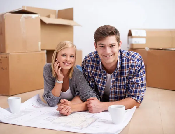 Man, woman and portrait with floor plan of new home for renovation or moving boxes, apartment or relocation. Couple, face and ground with coffee or blueprints for house, development or improvement.