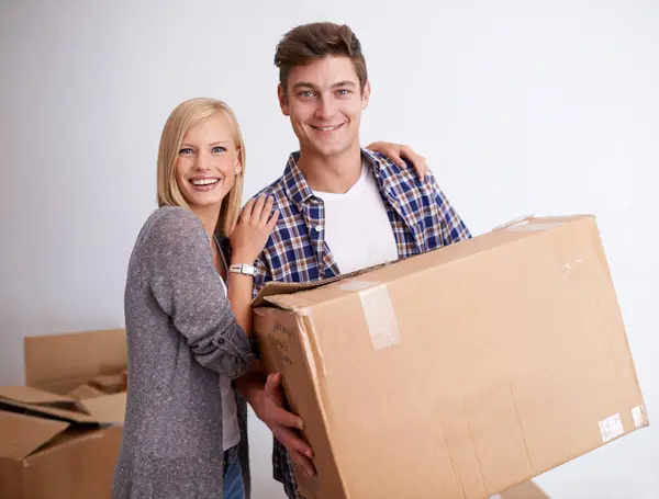 Couple, moving and new house with box for packing, happy with real estate and support in portrait and smile. Property, investment and people with cardboard package for relocation, mortgage or rent.