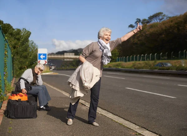 公路和老朋友一起搭便车去冒险 逃跑或退休旅行 微笑或快乐 并与在人行道上度假的老年妇女握手致意 — 图库照片
