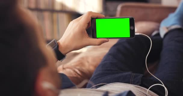 智能手机和绿色屏幕 在客厅里模拟空间 放松和在家里的手机上做广告 公寓内用于在线连接 社交媒体或数字收音机的手 音乐或手机 — 图库视频影像