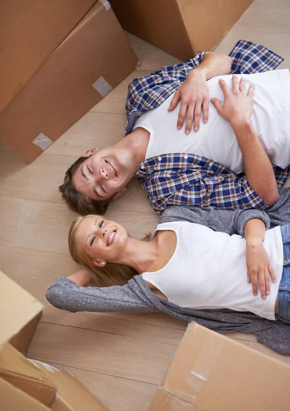 Couple, floor and moving or boxes for relax from packing or real estate property or bonding, marriage or apartment. Man, woman and rest for investment loan or mortgage for relocation, rent or buy.