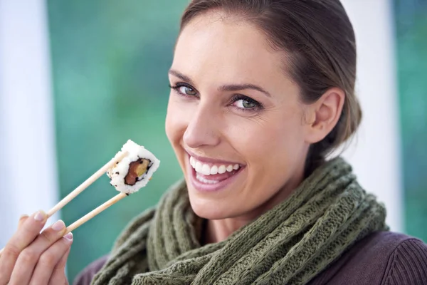 Woman, eating sushi and healthy food in portrait, lunch or dinner, Japanese cuisine and seafood with chopsticks. Catering, hungry and diet, relax with meal at home and happy with dish for nutrition.