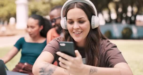音楽付きのヘッドフォン スマートフォン コミュニケーションとダンスのキャンパスの学生 チャット インターネットと大学ラジオのプレイリストを聞く ソーシャルメディアやモバイルアプリのためのオンライン — ストック動画