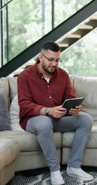 应用和快乐的男人放松在沙发上与社交媒体 滚动或阅读博客在他的家 在有电子书选择 浏览或网络通讯功能的客厅里的平板电脑 搜索和男性个人 — 图库视频影像