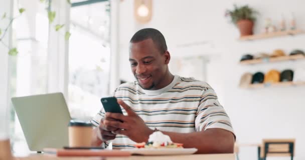 咖啡店 电话和快乐的黑人男子为远程工作打字 社交媒体或阅读电子邮件通知 智能手机 微笑或餐厅里的人 自由撰稿人或移动应用程序上的滚动 以获得有趣的迷因 — 图库视频影像