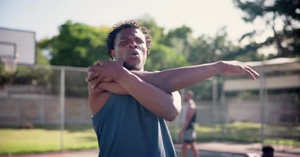 スポーツ バスケットボール アスリートは トレーニング ゲーム 屋外コートでの試合のための腕を伸ばします フィットネス チーム 若いアフリカの男性の健康 暖かいトレーニングや外のピッチでの運動 — ストック動画