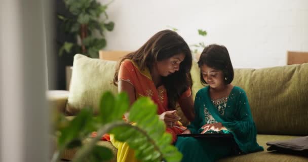 孩子和电子学习与平板电脑在家里客厅的沙发上进步 阅读和应用在线课程 印度家庭住房中的教育 拥有数码触摸屏的母女女童 — 图库视频影像
