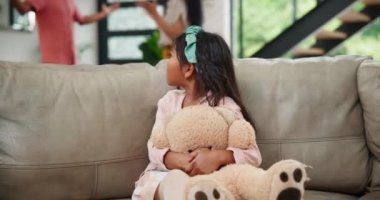 Kavga, anne-baba ve kız kanepede oyuncak ayıyla gürültü, bağırış çağırış ya da toksik madde yüzünden rahatlamak için. Aile, stres ya da bir oturma odasında elleri kulaklarında çocuk, endişe ya da çatışma korkusu.