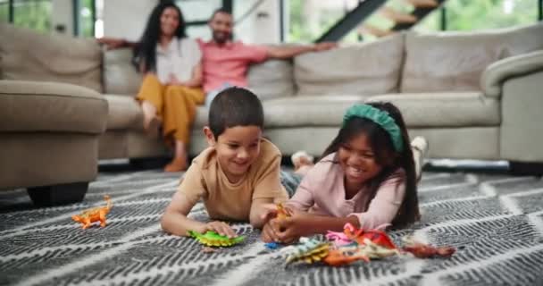 子供たち 恐竜のおもちゃで遊んで ラウンジでゲームし 開発で幸せで楽しくリラックスしてください プラスチックの爬虫類および家族のための動物が付いている床の兄弟 — ストック動画