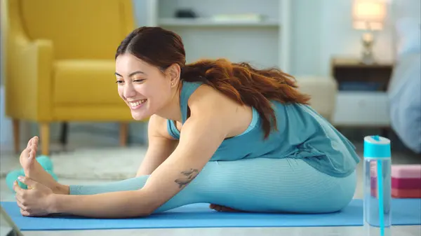 Woman, yoga and stretching for fitness, wellness in healthy spiritual zen exercise for mental wellbeing at home. Female in calm, relax and peaceful exercising workout for mind, body and spirit on mat.